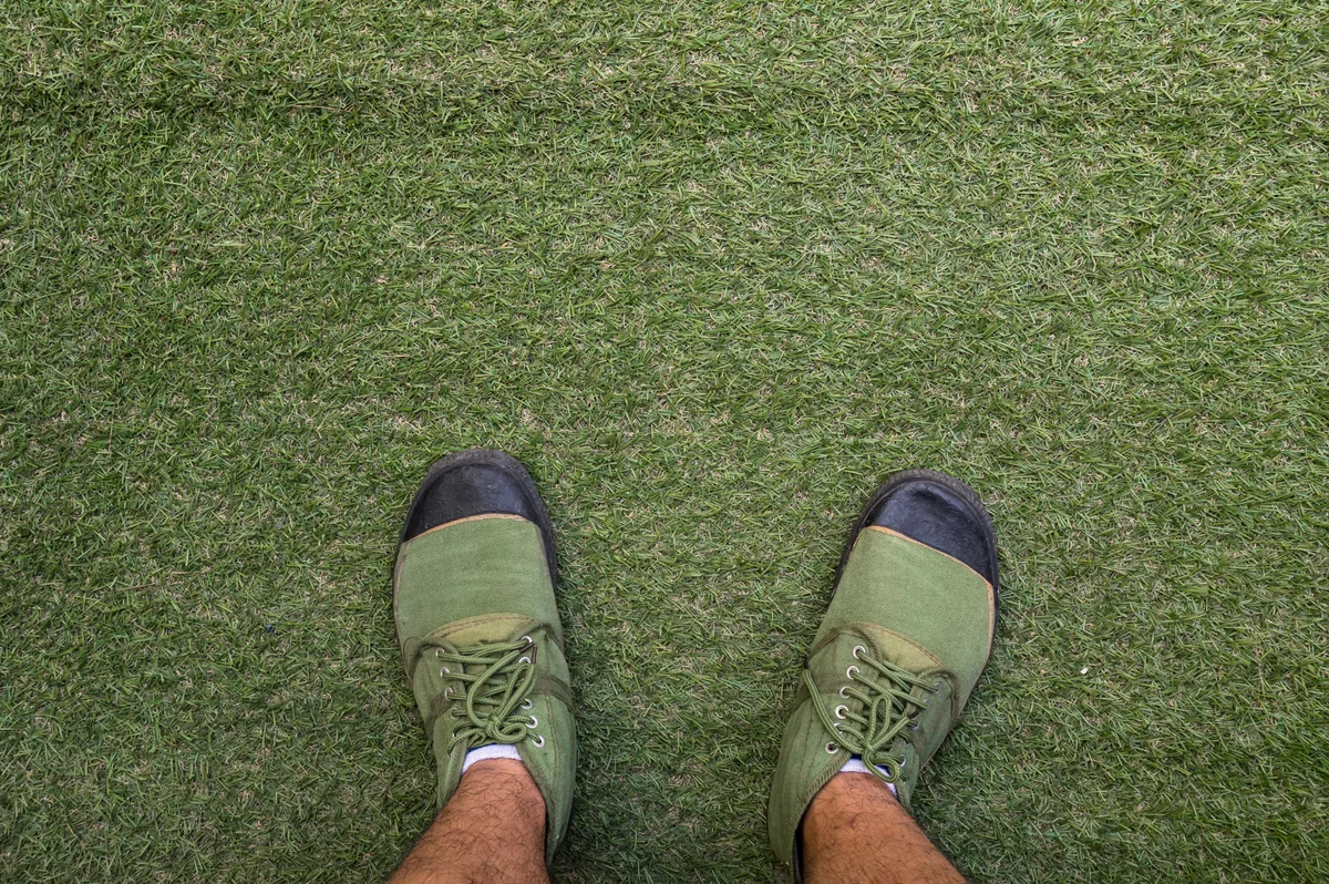 Técnico de Grupo Mundo Verde instalando pasto sintético profesionalmente en un jardín residencial de Guadalajara